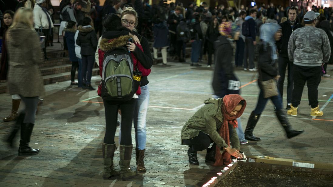 People embrace near a makeshift memorial at the close of a February 11 vigil.