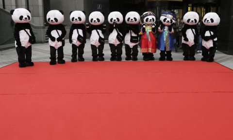 Workers wearing panda costumes wait for the start of a promotional event in front of a department store in Seoul, South Korea, on Tuesday, February 10.