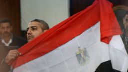 Al-Jazeera journalist Egyptian-Canadian Mohamed Fahmy holds the Egyptian flag at the court in Cairo February 12, 2015. An Egyptian court ordered the release of two Al-Jazeera journalists pending their retrial for allegedly supporting the banned Muslim Brotherhood. Fahmy was ordered to pay bail of 250,000 Egyptian pounds ($33,000) while Egyptian Baher Mohamed was released on his own recognisance along with other defendants. AFP PHOTO/ MOHAMED EL-SHAHEDMOHAMED EL-SHAHED/AFP/Getty Images