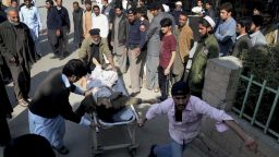 People rush an injured person to a hospital following an attack involving suicide bombers and gunmen at a Shiite mosque in Peshawar, Pakistan, Friday, Feb. 13, 2015. Militants stormed a Shiite mosque in northwestern Pakistan on Friday, killing many people in a wave of shooting and explosions before the siege ended, officials said. (AP Photo/Mohammad Sajjad/AP)