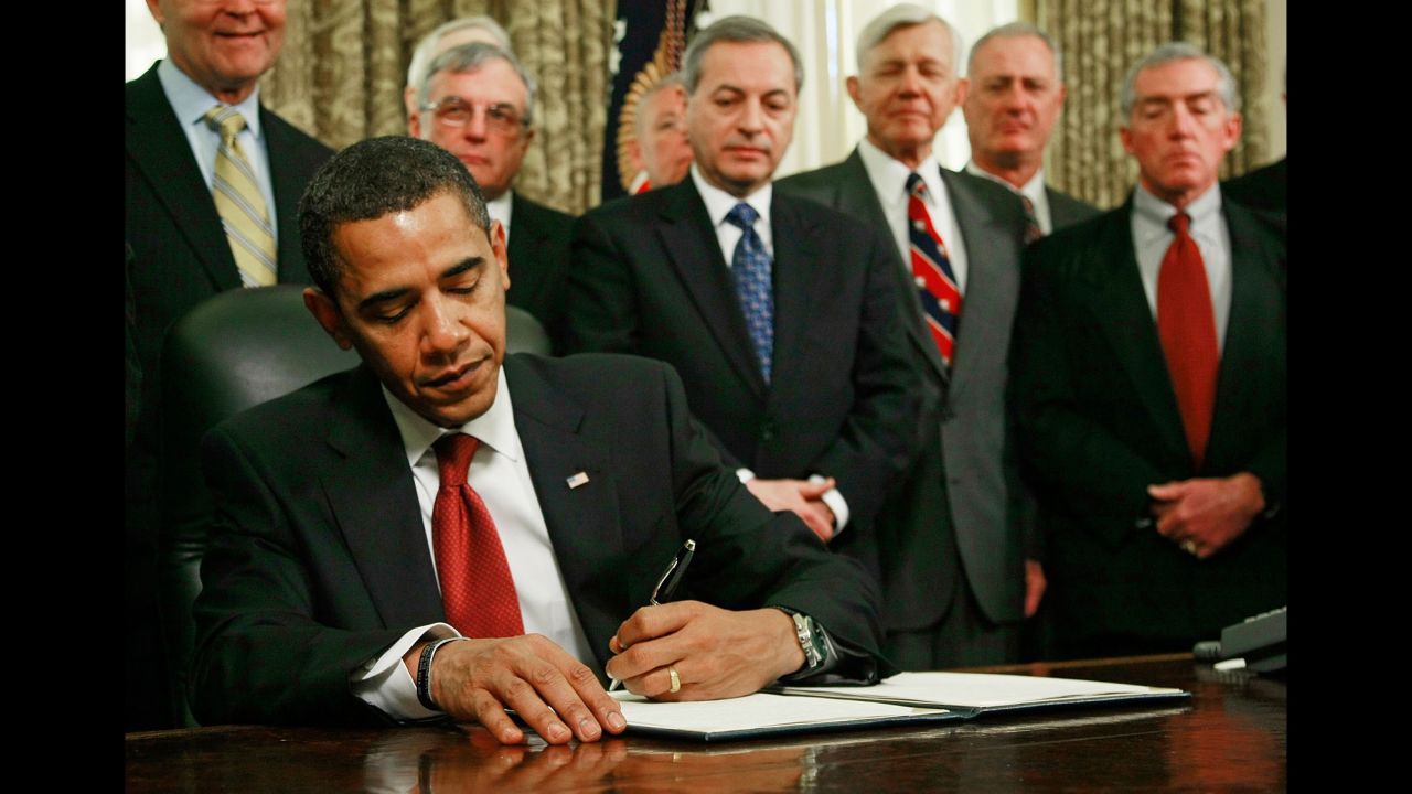As retired military officers stand behind him, Obama signs an executive order to close down the detention center at Guantanamo Bay in January 2009.