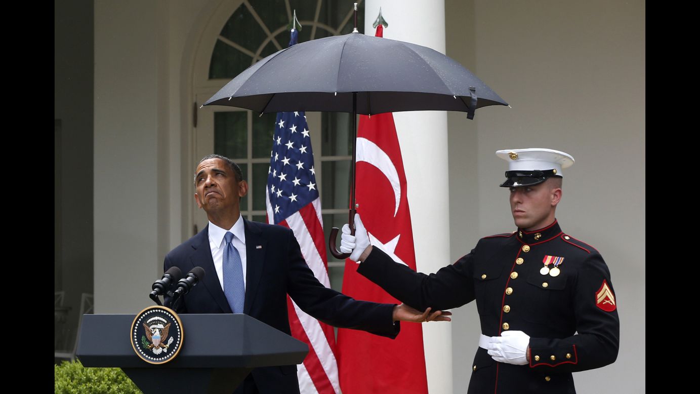 Obama adjusts an umbrella held by a Marine during a White House news conference with Turkish Prime Minister Recep Tayyip Erdogan in May 2013.