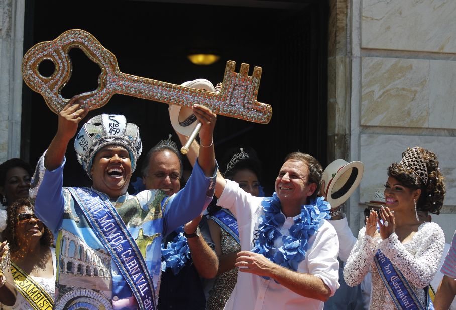 The 2015 Carnival King, "King Momo" Wilson Dias da Costa Neto, holds up the key to the city of Rio de Janeiro with Mayor Eduardo Paes, center, and Carnival Queen Clara Paixao, right, on February 13.