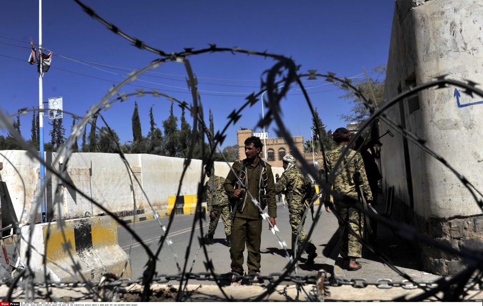 Houthi fighters guard the gate of the presidential palace where a bomb went off and wounded three people in Sanaa on Saturday, February 7.