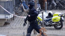An armed security officer runs down a street near a venue after shots were fired where an event titled "Art, blasphemy and the freedom of expression" was being held in Copenhagen, Saturday, Feb. 14, 2015. Danish media say several shots have been fired at a cafe in Copenhagen where a meeting about freedom of speech was being held, organized by Swedish artist Lars Vilks, who has faced numerous threats for caricaturing the Prophet Muhammad in 2007. (AP Photo/Polfoto, Kenneth Meyer) DENMARK OUT