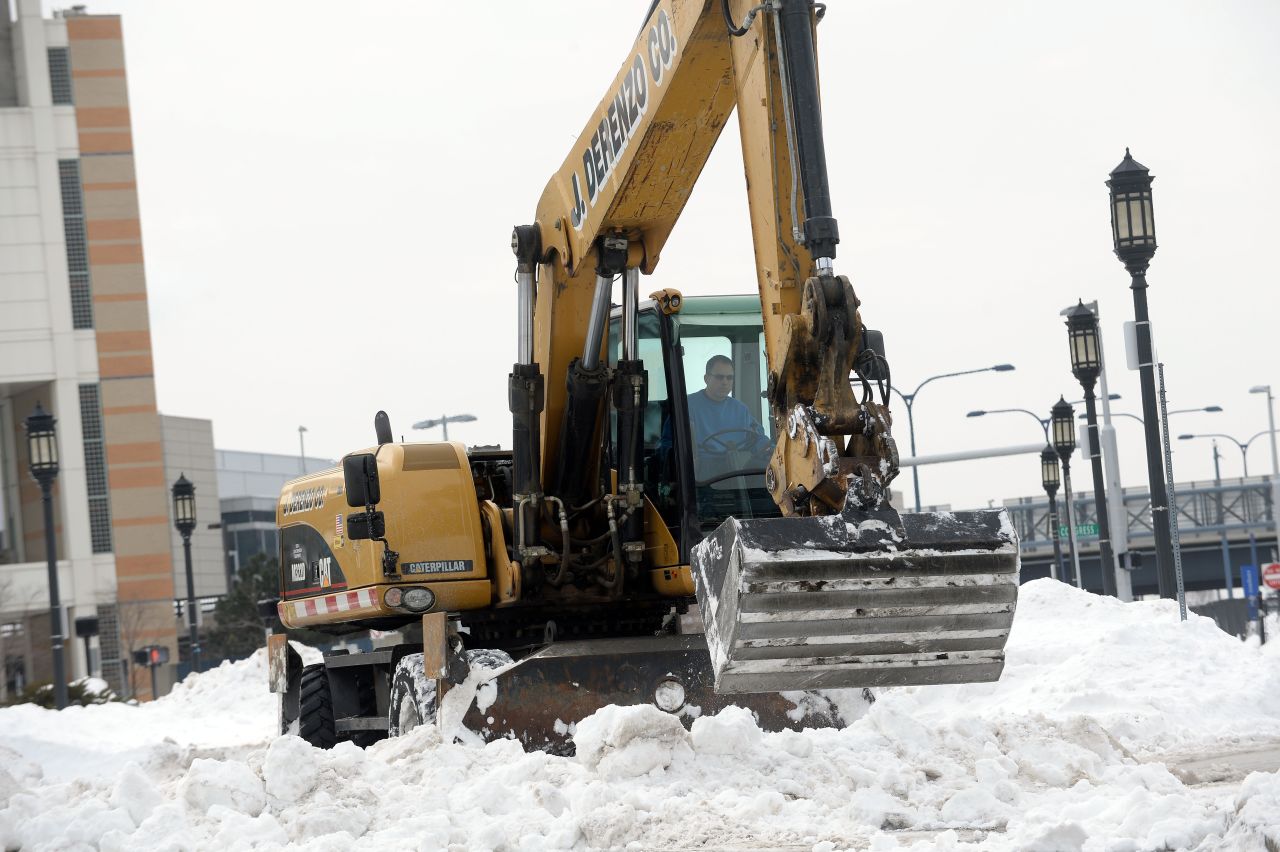 Heavy machinery works on snow banks on East Service Street in Boston on February 14.