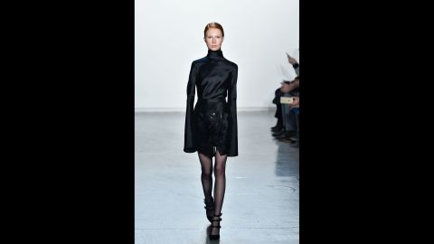 A model walks in a tailored turtleneck look with extended cuffs for Misha Nonoo.