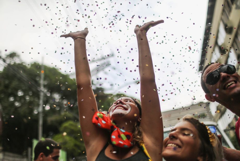 A reveler tosses confetti into the air while taking a group selfie at a parade in Rio de Janeiro on Saturday, February 14.