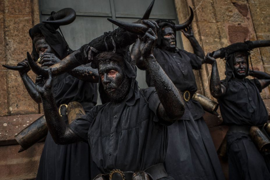 People with their faces covered in oil and soot carry bull horns as they represent devils at a Carnival festival in Luzon, Spain, on February 14. 