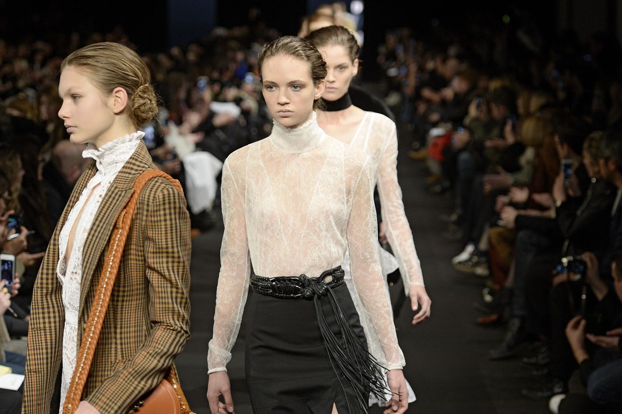 A model walks the runway in a high, lace neckline for Altuzarra.