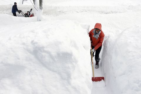 Kim Taylor of Norwood, Massachusetts, shovels a path in the snow in front of her home on February 15. 
