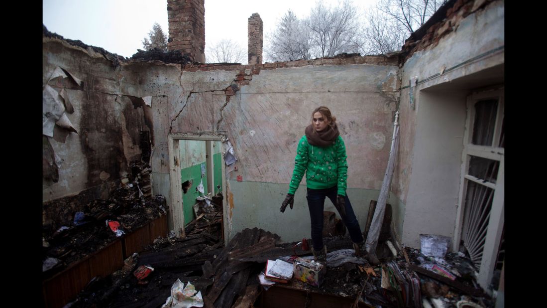 A woman salvages items February 15 from the rubble of a destroyed clinic where she had worked in Opytne, Ukraine.