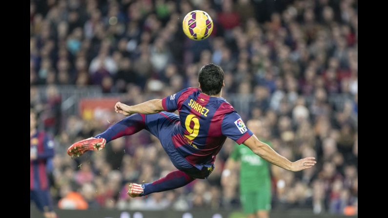 Barcelona striker Luis Suarez twists his body before volleying the ball into the net Sunday, February 15, during a Spanish league match against Levante. Barcelona won the match 5-0 and moved to within a point of league leaders Real Madrid.