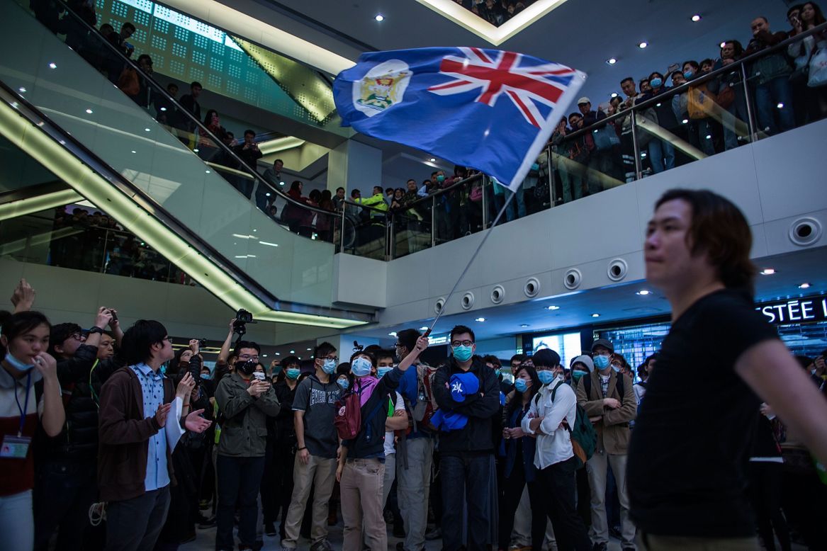 A protestor waves a Hong Kong colonial-era flag during the protest, a sign of defiance against mainland China.