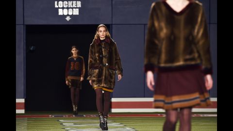 Models walk down a football stadium runway for Tommy Hilfiger's sporty fall collection.