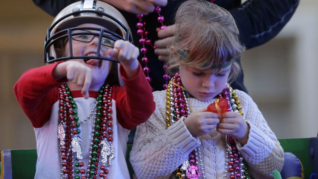 Barker Curry, 4, cheers while his cousin Sophia Curry, 3, looks at one of her trinkets during the Krewe of Proteus Mardi Gras parade on February 16.