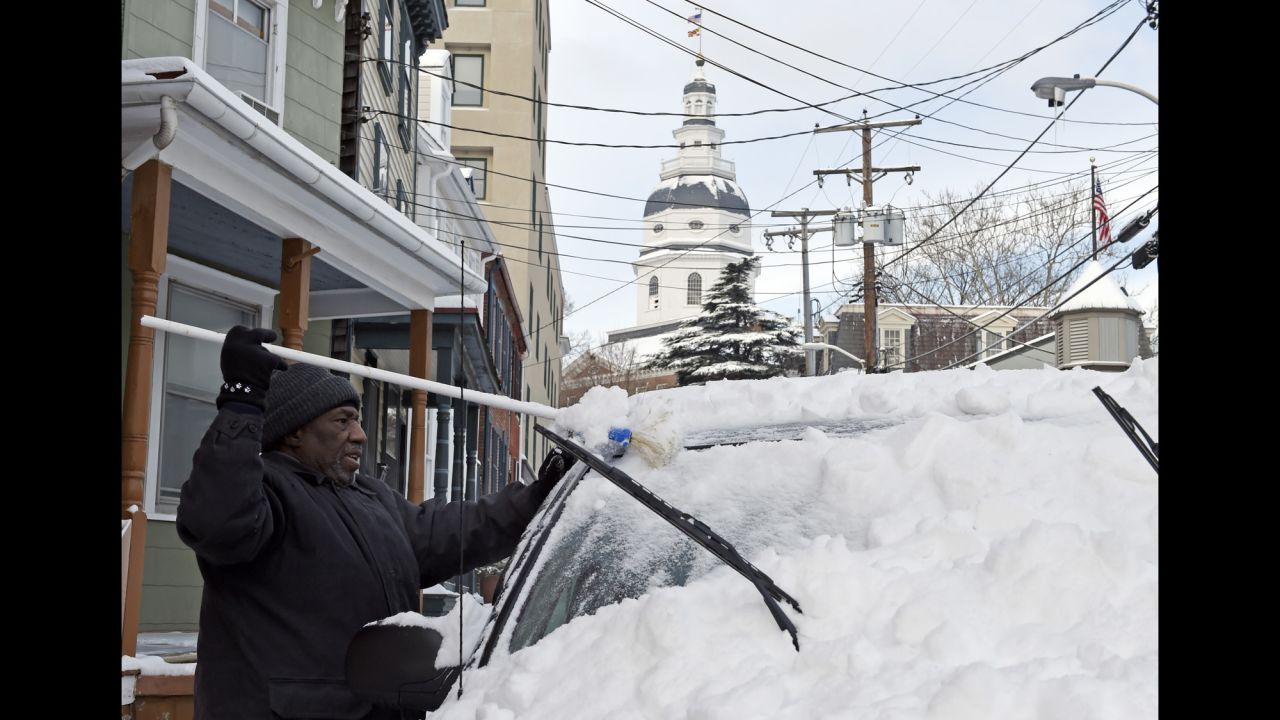 Mike Simms clears snow from his car in Annapolis, Maryland, on Tuesday, February 17. Wintry weather spread along the East Coast and across parts of the South leaving tens of thousands without power.