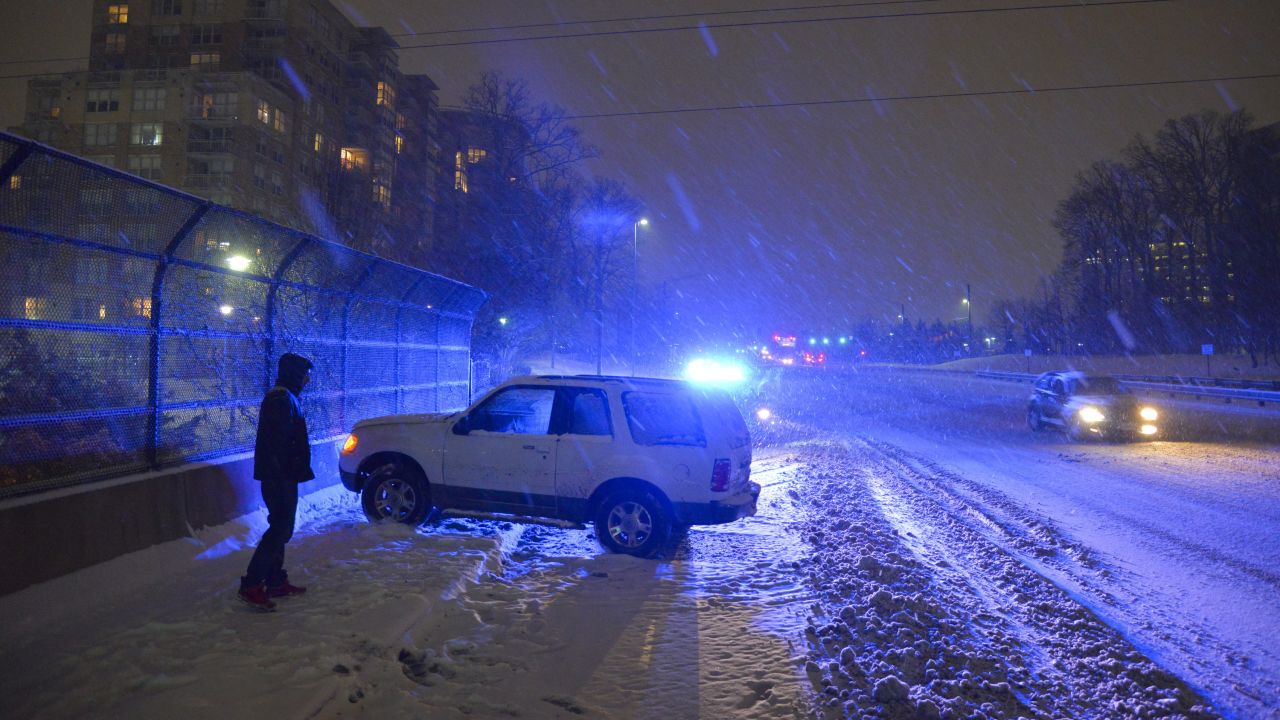 Daniyal Maveed waits to have his vehicle towed after sliding out of control in Reston, Virginia, on Monday, February 16.