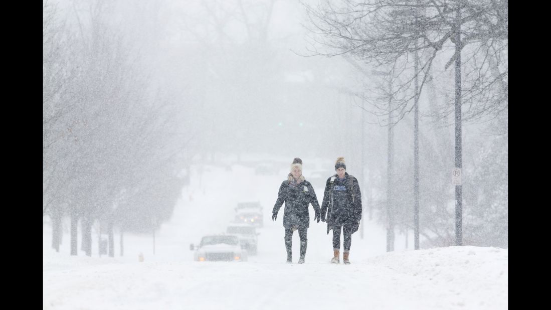 University of Kentucky students Courtney Wiseman, left, and Abby Lerner walk in the falling snow in Lexington, Kentucky, on February 16.