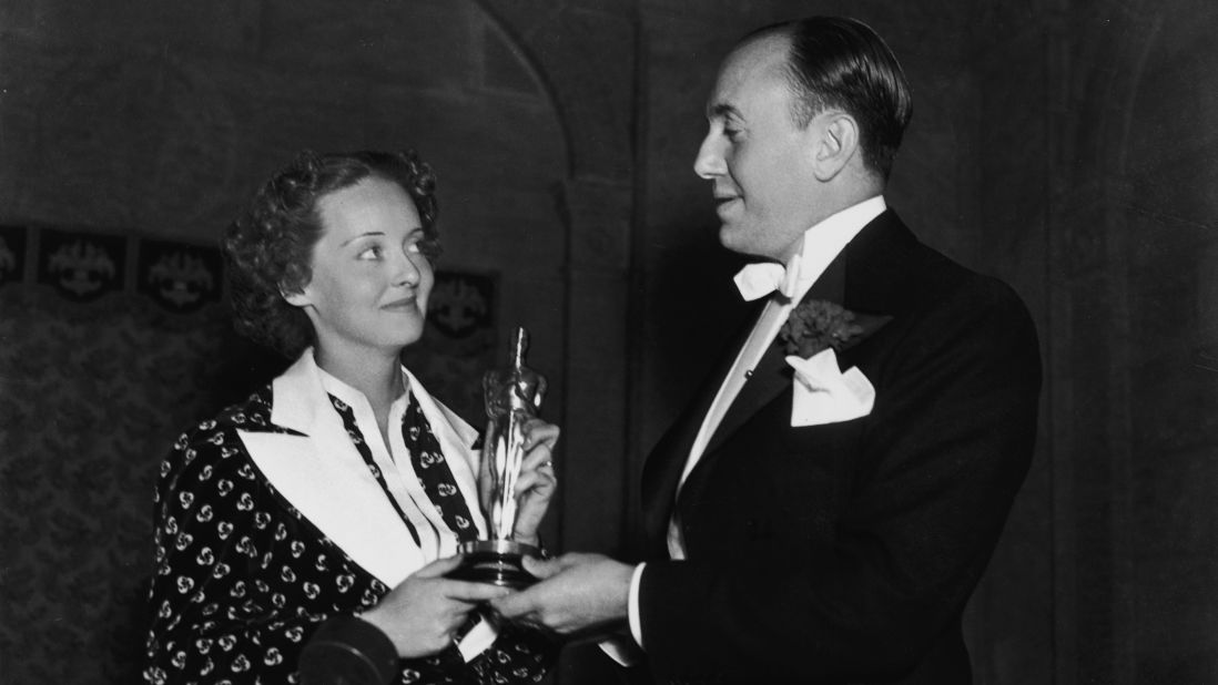 <strong>Bette Davis (1936):</strong> Bette Davis and film producer Jack L. Warner hold Davis' best actress Oscar at the ceremony held in 1936. Davis won her first Oscar for her role in the film "Dangerous."