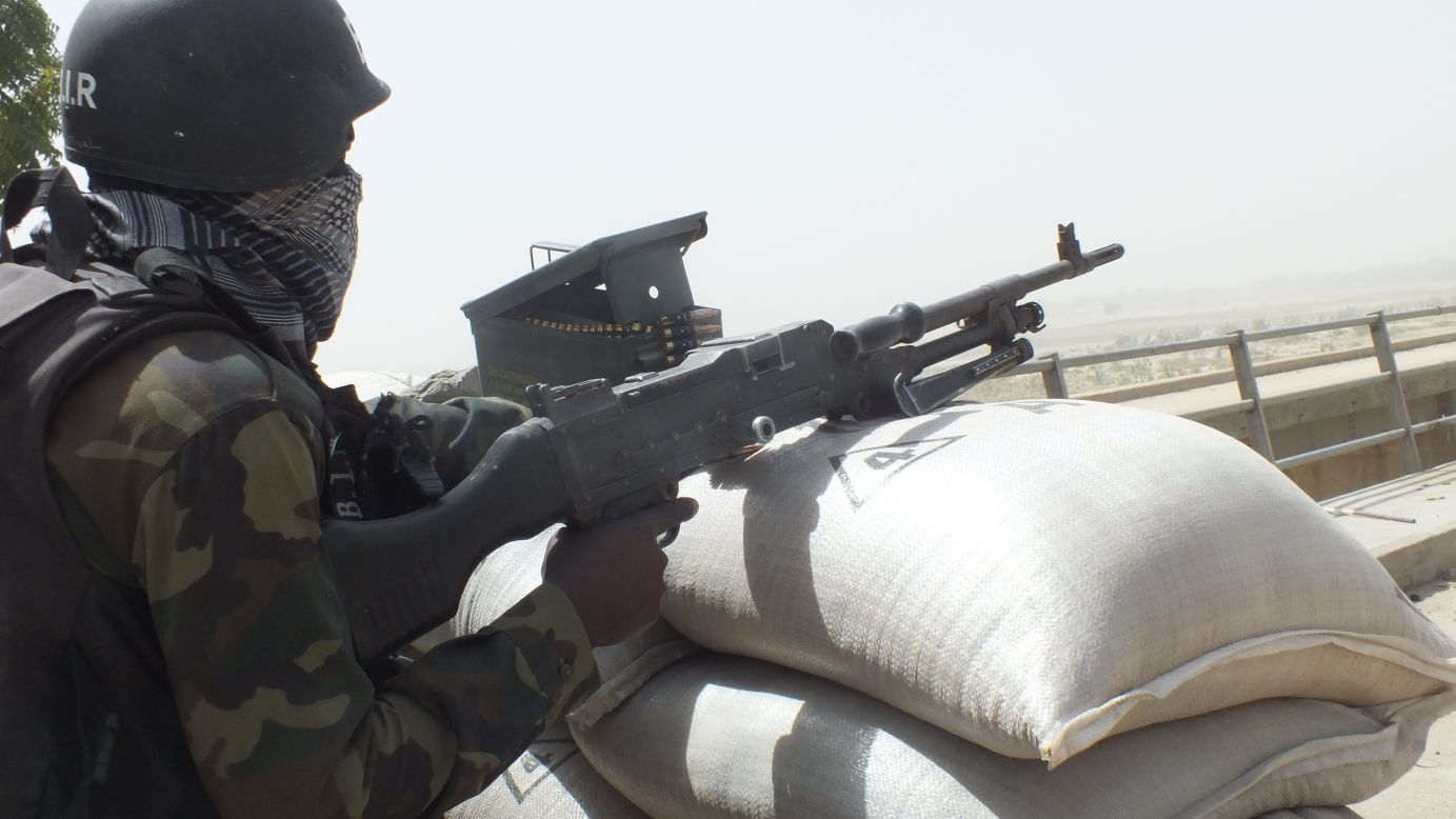 A Cameroonian soldier points his gun across the El Beid Bridge into Gambaru, Nigeria. Gambaru is considered one of the strongholds of Boko Haram.