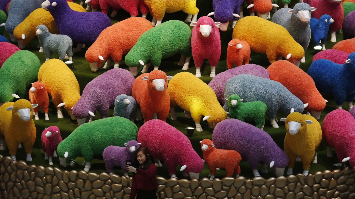 A woman at a Hong Kong shopping mall takes a selfie in front of colored sheep on Friday, February 13. It was a display for the upcoming <a href="http://www.cnn.com/2015/02/08/asia/gallery/lunar-new-year-2015/index.html" target="_blank">Lunar New Year,</a> which will welcome the Year of the Sheep.
