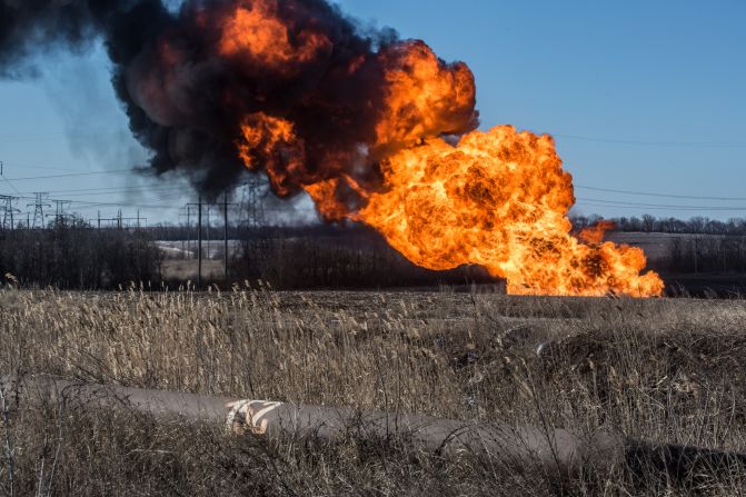 A gas pipe burns after being struck by shelling in Myronivskyi.
