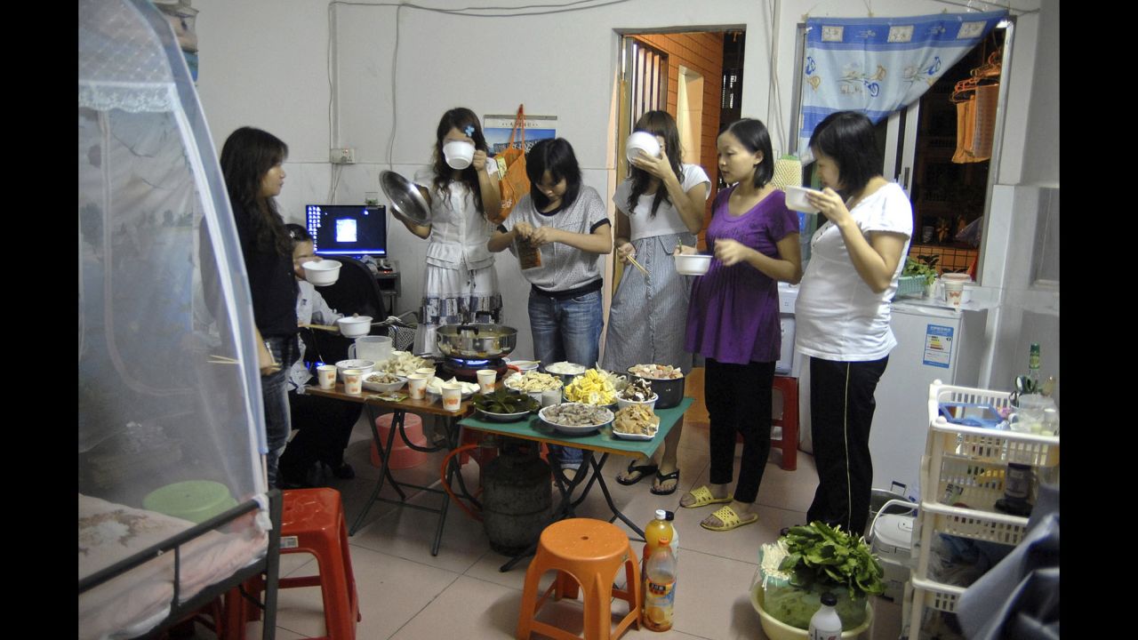 Migrant workers enjoy a dinner party in a rented room in Dongguan.