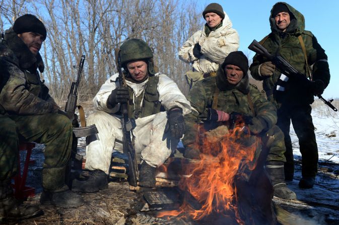 Pro-Russian rebels warm themselves by a fire during a break between fighting.