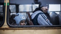 A Ukrainian kid and a Ukrainian young boy sit in a bus before fleeing Debaltseve, in the Donetsk region, on February 3, 2015. At least 19 civilians and five government troops were killed over the previous 24 hours as fierce clashes raged between pro-Russian separatists and Ukraine's outgunned forces in the east of the country, insurgent and government officials said.
