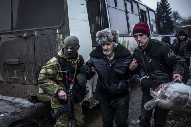 An elderly Ukrainian man is helped by a Ukrainian Army soldier and a citizen during a evacuation of civilians in Debaltseve.