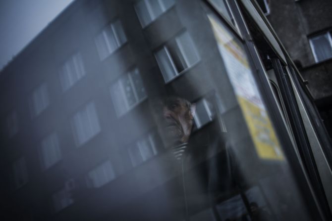 An elderly Ukrainian man stands inside a bus before being evacuated from the region.