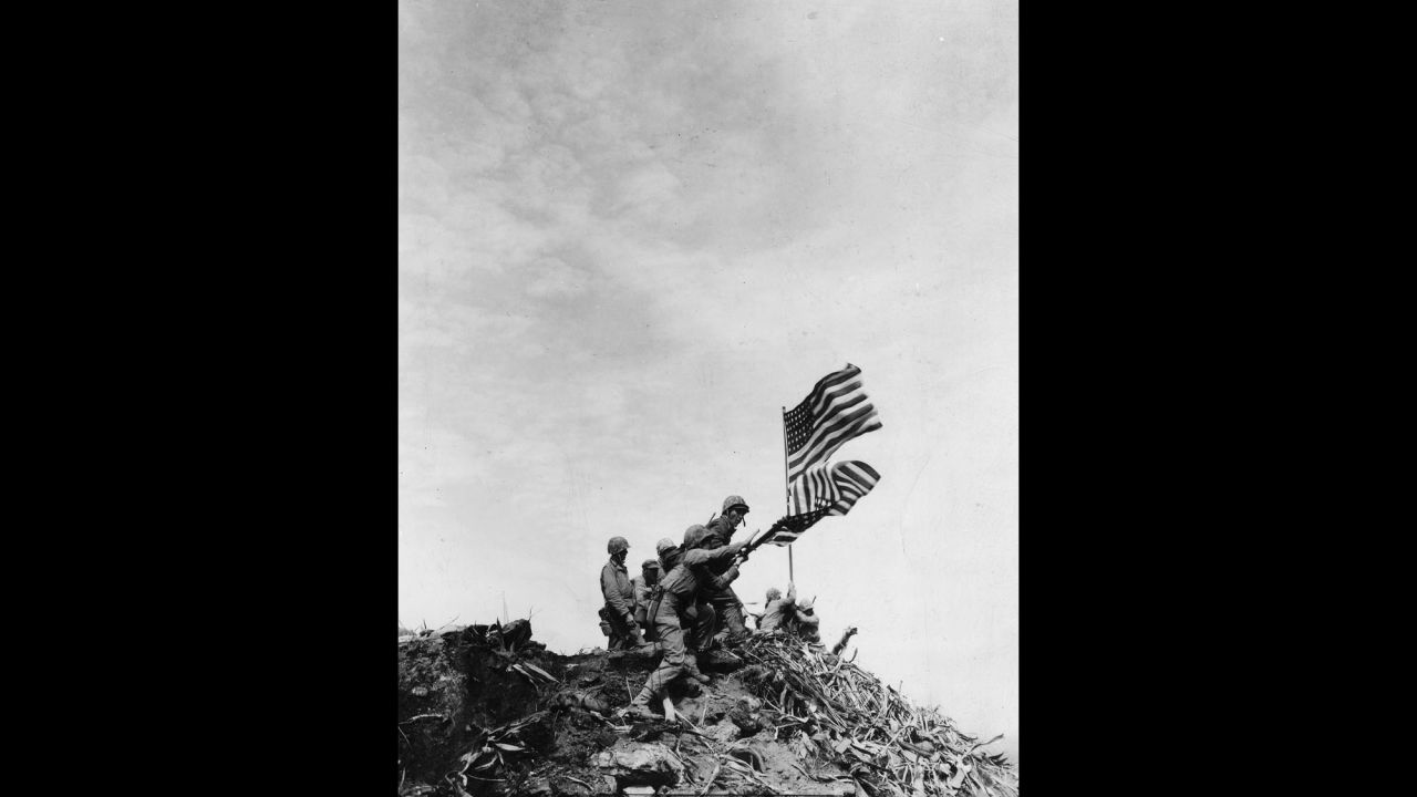 When Marines replaced the smaller flag with the bigger one, they lowered and raised the flags simultaneously, as seen in this photo by Campbell. 