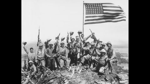 This image is referred to as Rosenthal's "gung ho" photo, in which Marines posed with the second flag while raising their rifles and helmets in the air. When Rosenthal was asked later if the image was posed, he said it was. That created confusion over whether his photo of the actual flag-raising was posed. For years many people thought it was, but it really was not. 