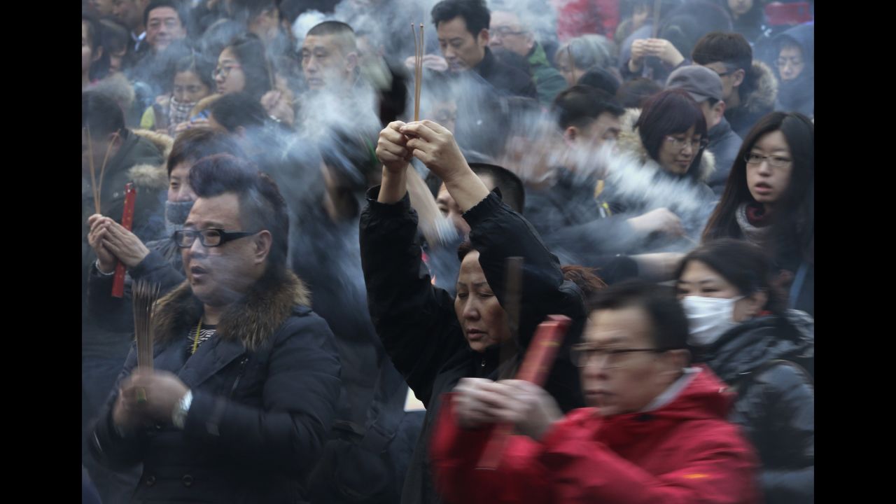 Worshipers burn incense while offering prayers at a temple in Beijing on February 19.
