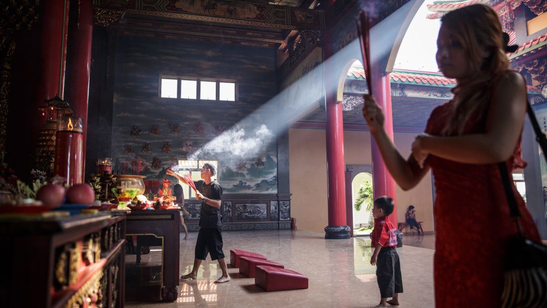 A man lights incense sticks at a temple in Denpasar, Indonesia, on February 19.