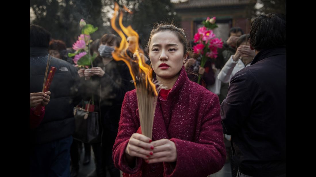 A woman holds incense at a Beijing temple February 19.