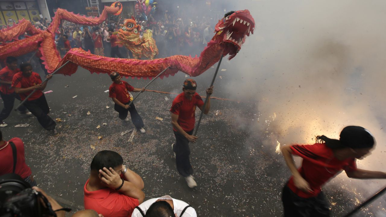 Firecrackers explode as dragon and lion dancers perform in front of a supermarket in Manila, Philippines, on February 19.