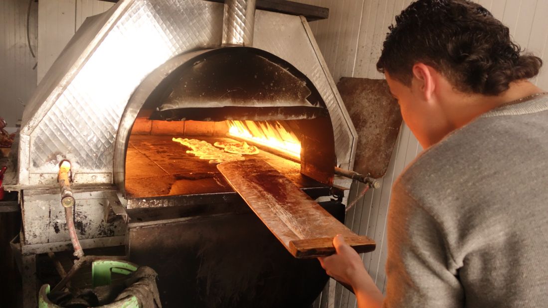 Pizzas bakes in an oven in the Zaatari camp, just across the border from Jordan. The pizza parlor's owner, Abu Mohamed, says his business his booming after he began offering pizza delivery by bicycle.