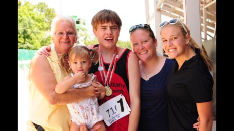 In May 2014, John won the gold medal for the 800 meters and the silver for the 110-meter hurdles at the Special Olympics State Summer Games in Orlando. Here, the 18-year-old poses with his family in a group photo. His mother, Rachel, is to his left. 