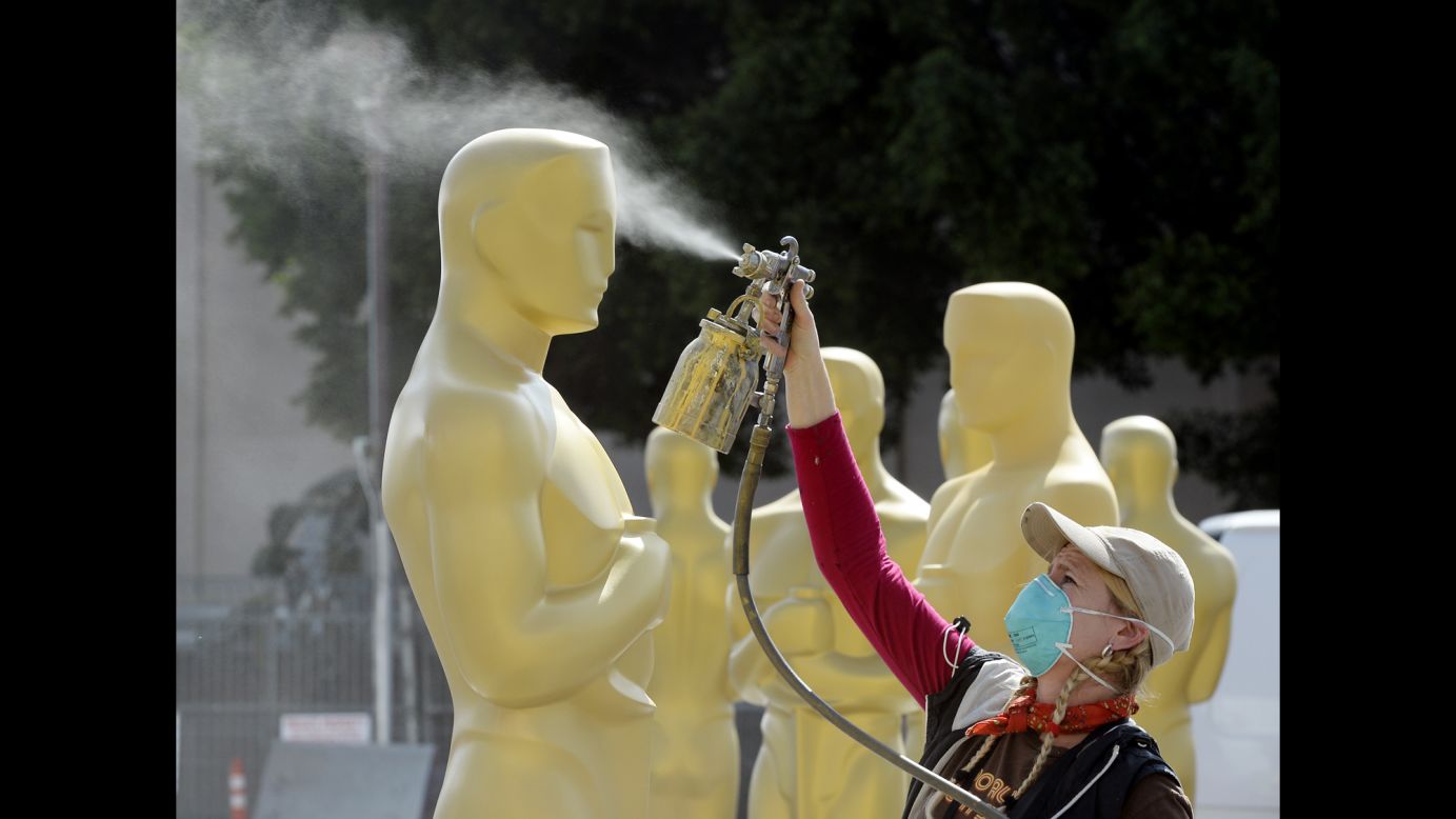 Dena D'Angelo spray-paints an Oscar statue on Wednesday, February 18, ahead of the Academy Awards show in Hollywood, California.