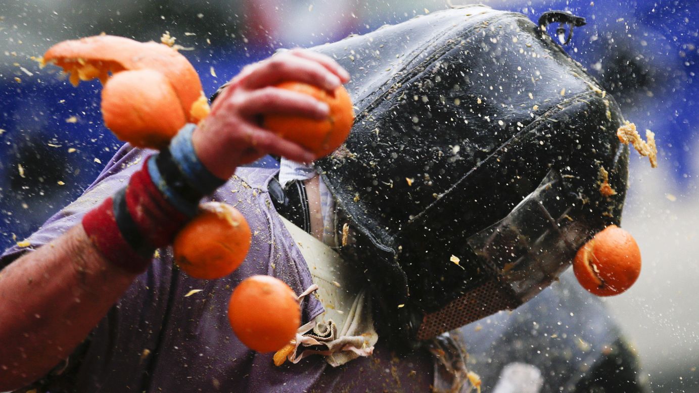 A person is hit by an orange on Sunday, February 15, during the annual Battle of the Oranges in Ivrea, Italy. The food fight re-enacts a Middle Age battle when the Ivrea townsfolk overthrew an evil king. But instead of swords and crossbows, oranges are now the weapons of choice.