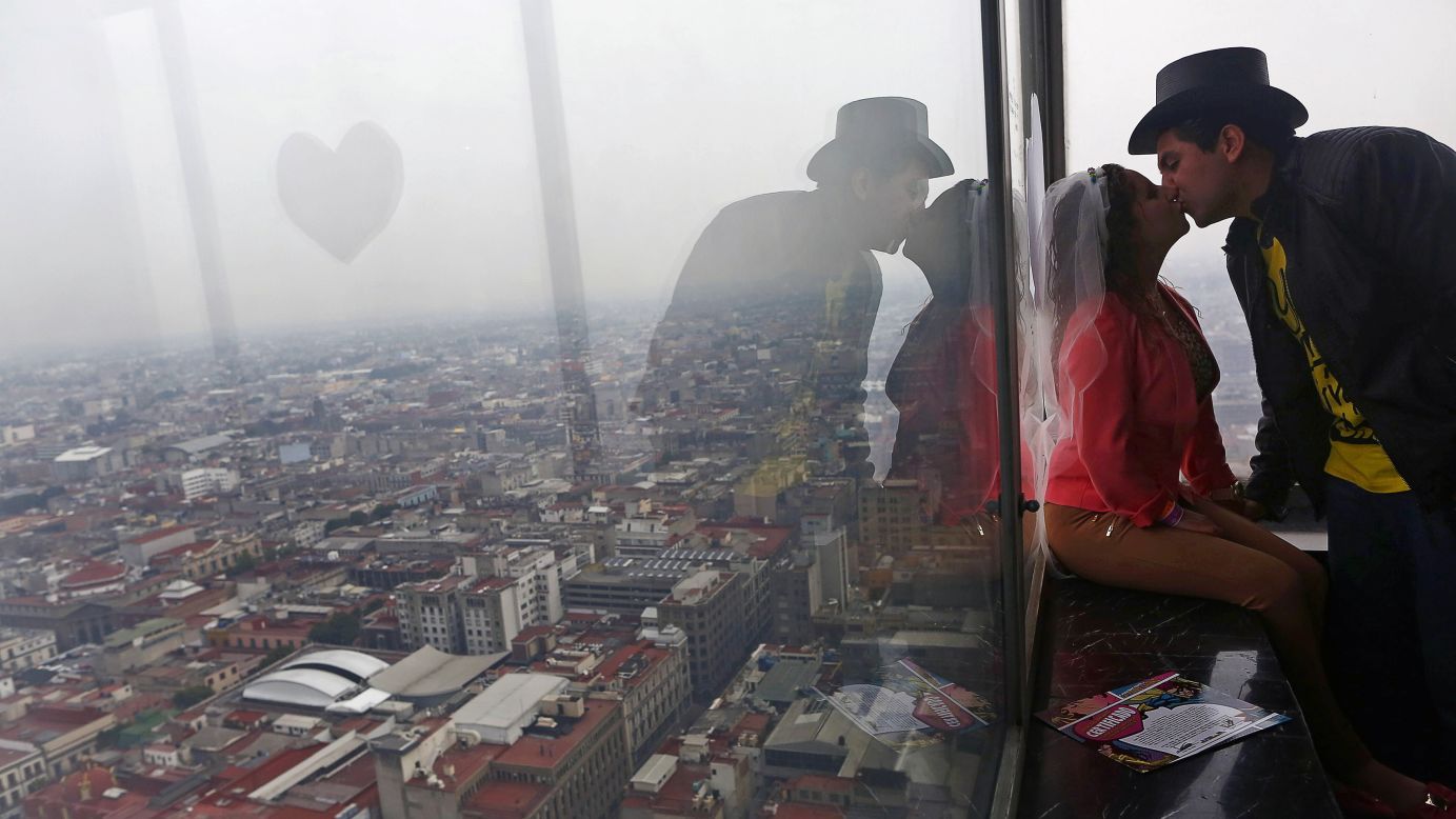 A couple kisses in Mexico City after being "married" by people dressed as comic-book characters during a Valentine's event on Friday, February 13. Couples received symbolic rings and a fake marriage certificate during the event, which was not legally binding.
