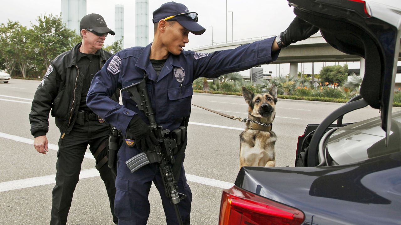 Officers inspect a car outside Los Angeles International Airport in 2013 after three TSA employees were shot.