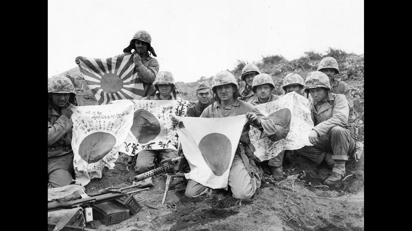 US troops display captured Japanese battle flags.