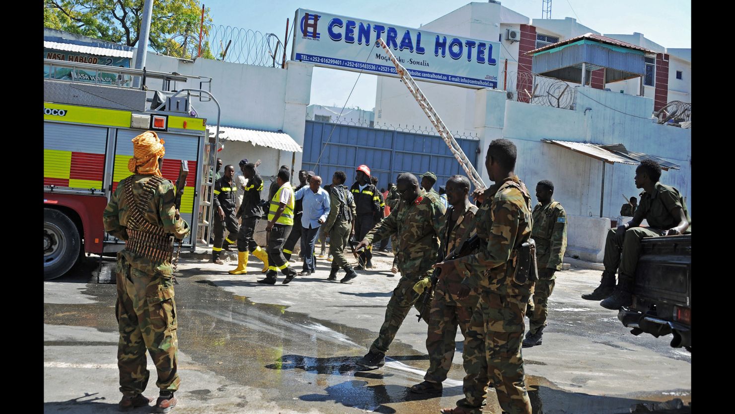 Somali security forces, medics and firefighters stand outside Mogadishu's Central Hotel after Friday's attack.