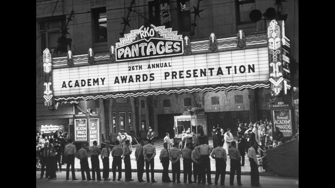 Parking attendants stand in front of Pantages Theatre as they await celebrity attendees to arrive for the 26th Academy Awards in Los Angeles in 1954.
