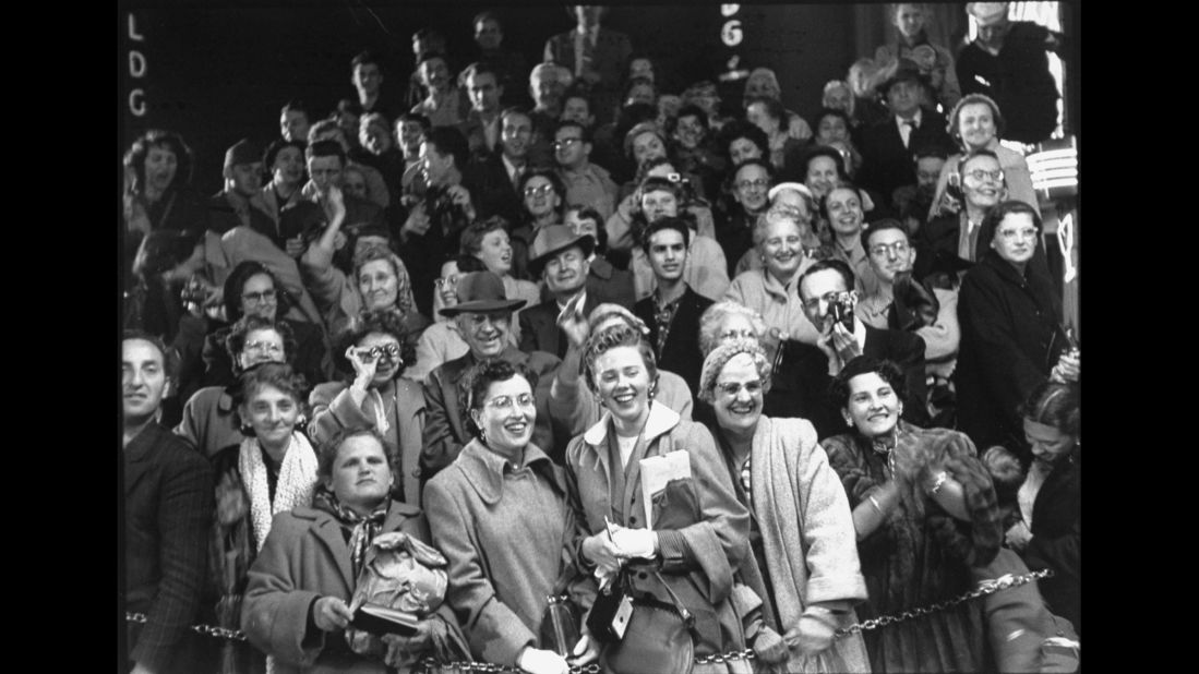 Crowd of fans watching as celebrities arrive at the RKO Pantages Theatre in 1954.