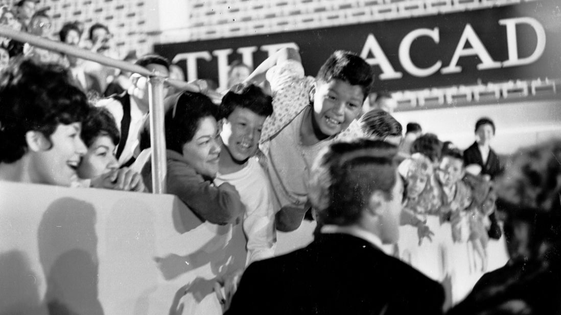 Excited fans greet Gregory Peck and his wife as they arrive at the Oscars ceremony in April 1962. 