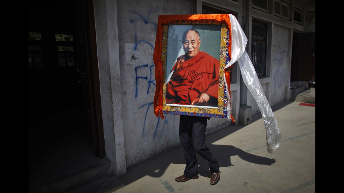 A Tibetan man in Katmandu, Nepal, carries a portrait of the Dalai Lama on April 25, 2012, during an event marking the 23rd birthday of Panchen Lama Gendun Choekyi Nyima, the second-highest Tibetan religious leader.